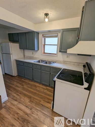 A kitchen with wooden floors and a white dishwasher.