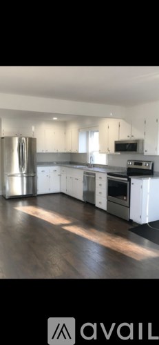 A modern kitchen with stainless steel appliances and white cabinets.