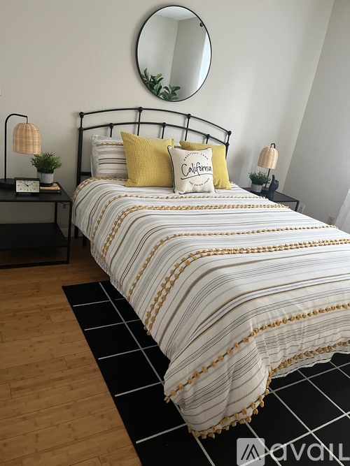 A bedroom with a bed, nightstands, and a mirror on the wall.