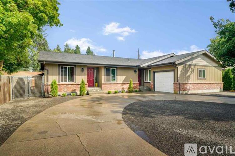 A house with a driveway and a garage is available for rent.