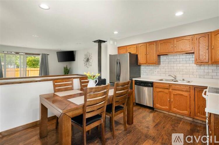 A kitchen with wooden cabinets and a black refrigerator.