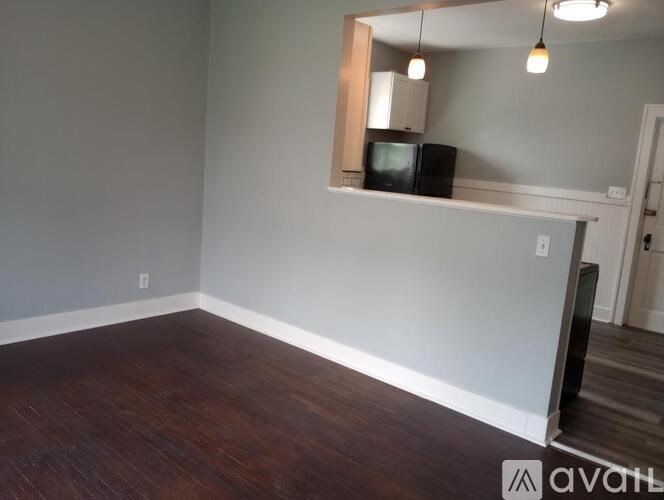 A room with a wooden floor and a mirror on the wall.