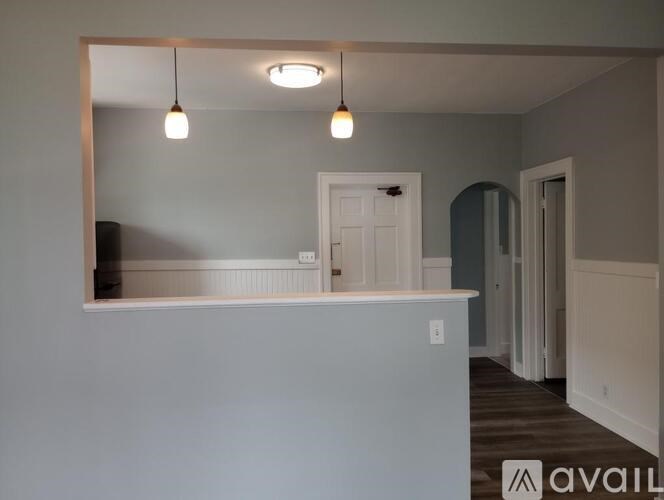 A room with a white cabinet and a mirror on the wall.