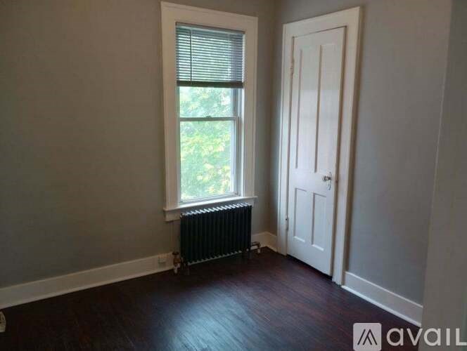 A room with a door, window, and radiator.