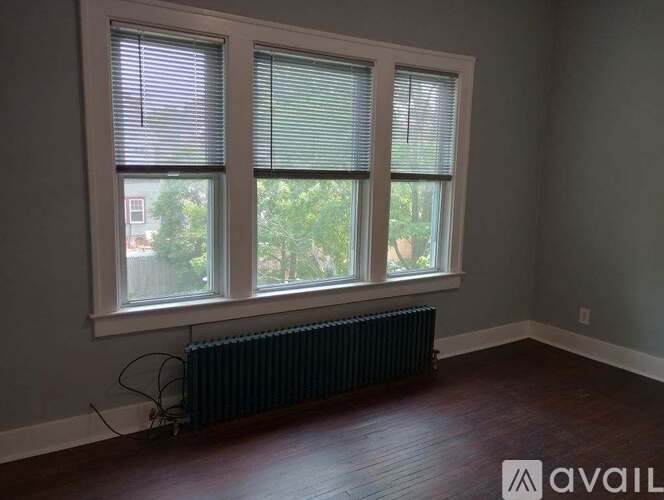 A room with a window and a radiator on the floor.