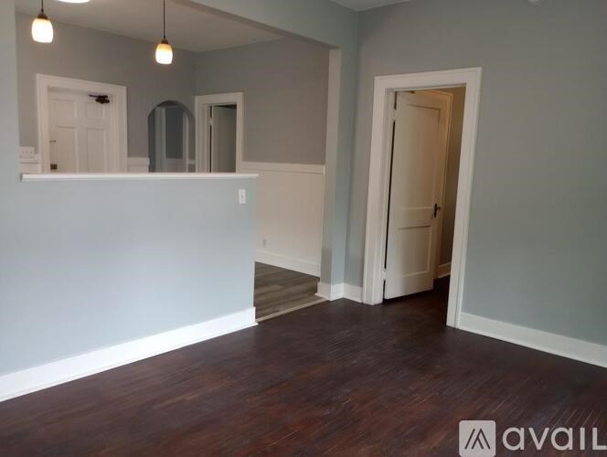 A room with a white wall and a wooden floor.