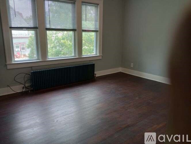 A room with a radiator and wooden flooring.