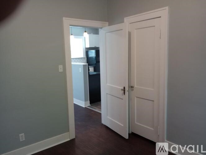 A room with a white door and a mirror on the wall.