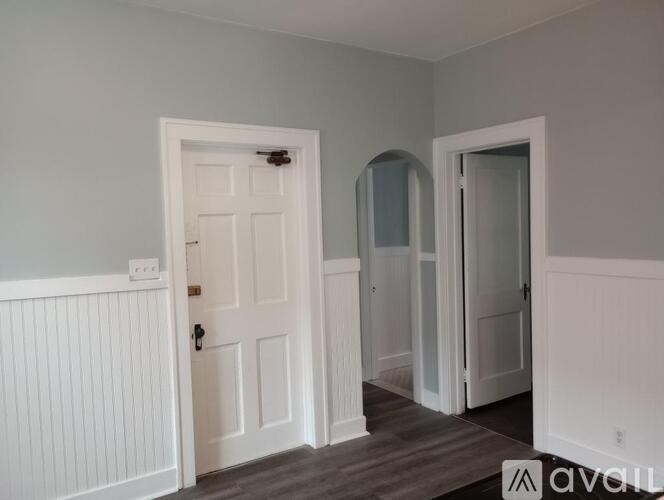 A room with a white door and a white wall.