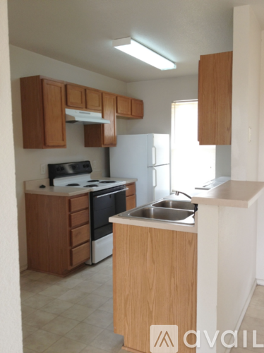 A kitchen with wooden cabinets and a white fridge.