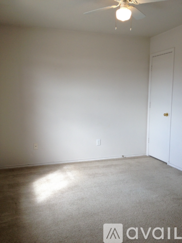 A room with a ceiling fan and a door.