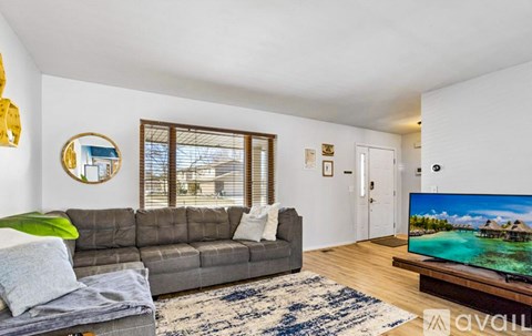 A living room with a grey sofa and a flat screen TV.