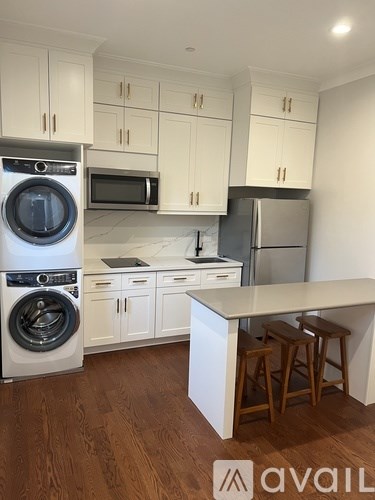 A kitchen with white cabinets and a wooden floor.