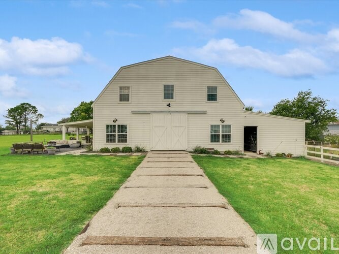 A large barn-like building with a long walkway leading to the front door.