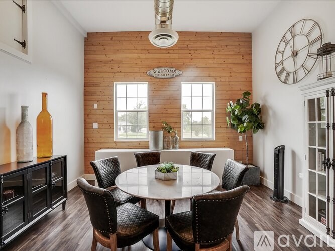 A dining room with a round table surrounded by chairs.
