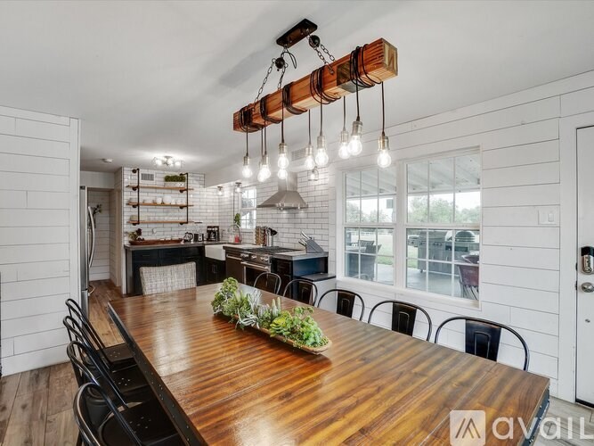 A wooden dining table with a bunch of green plants on it.