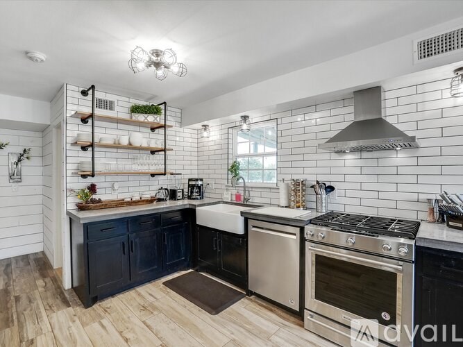 A modern kitchen with a stainless steel oven and black cabinets.