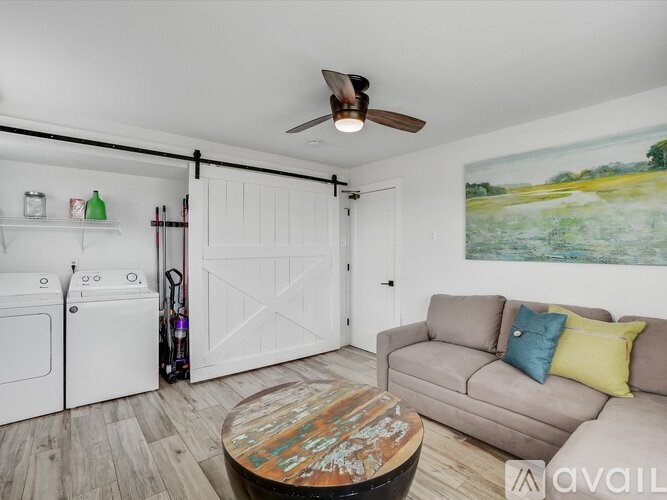 A living room with a couch, a coffee table, and a painting on the wall.