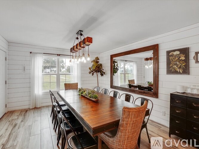 A dining room with a wooden table and chairs.