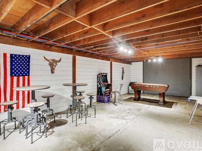 A room with a wooden ceiling and a large American flag on the wall.