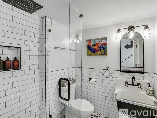A bathroom with a white tiled wall and a white toilet.