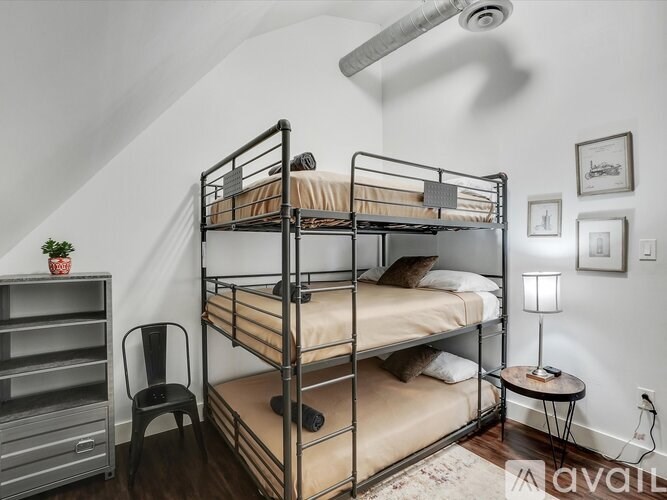 A room with a bunk bed and a chair.