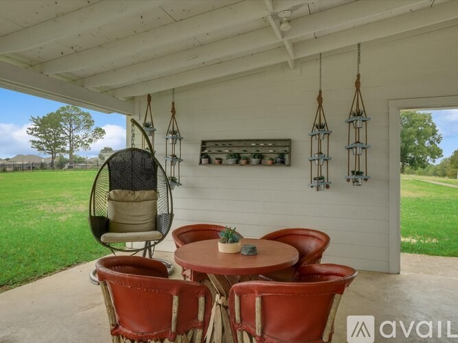 A patio with a table and chairs and a hanging chair.