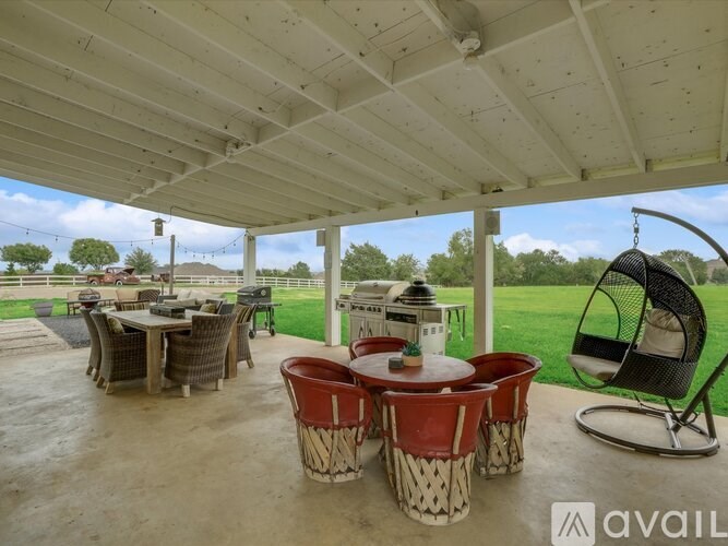 A covered patio with a table and chairs.