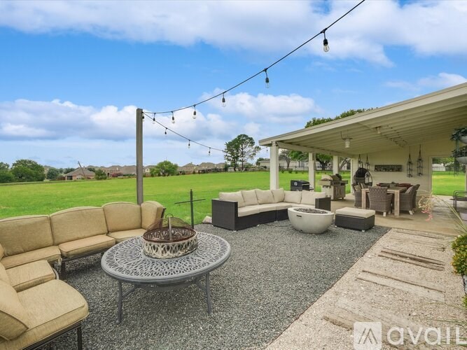 A patio with a table, chairs, and a sofa.