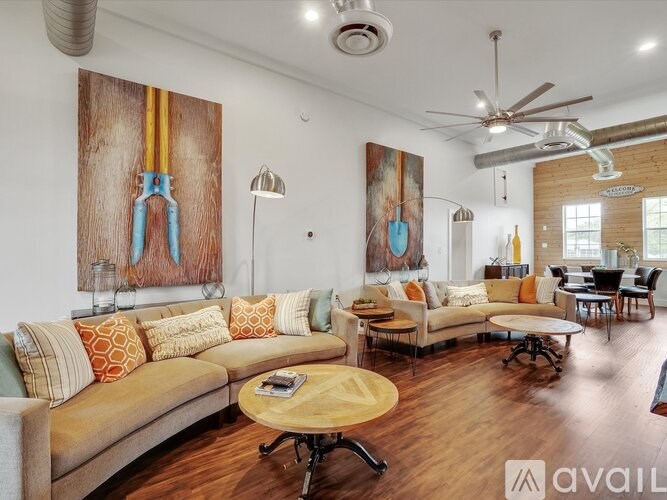 A living room with a large couch and a painting on the wall.