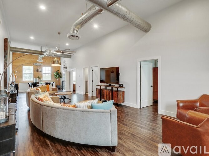 A living room with a couch, chairs, and a fan.