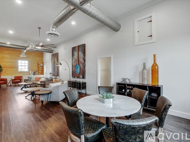A living room with a white table surrounded by chairs.
