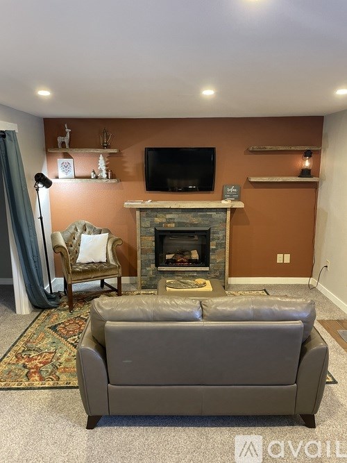 A grey couch is in front of a fireplace in a living room.