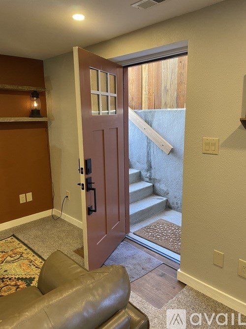 A brown door is open to a staircase.
