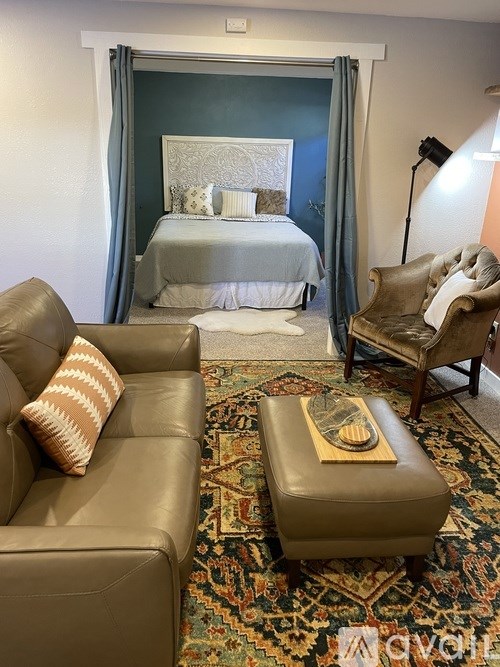 A bedroom with a bed, a chair, and a couch.