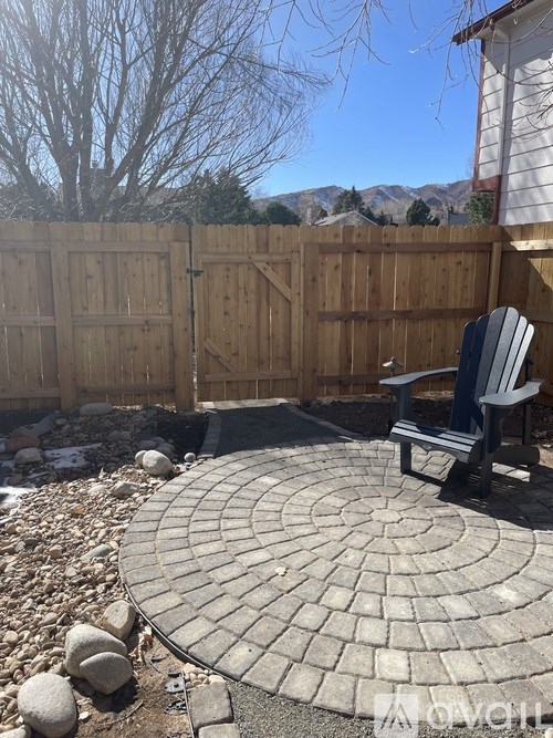 A patio with a table and chairs and a view of the mountains.