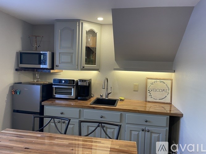 A kitchen with a wooden counter top and a fridge.