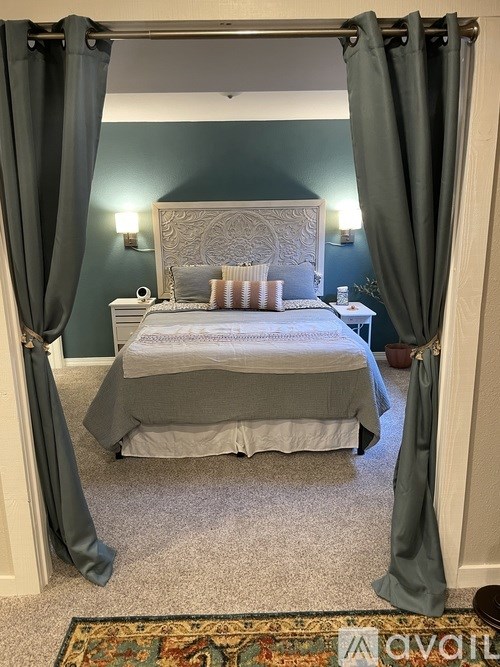 A bedroom with a bed, nightstand, and two lamps.