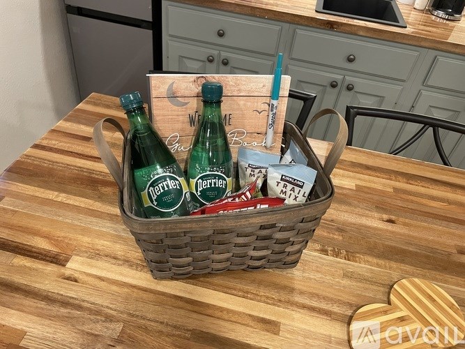 A picnic basket with a bottle of Perrier water and a can of trail mix.