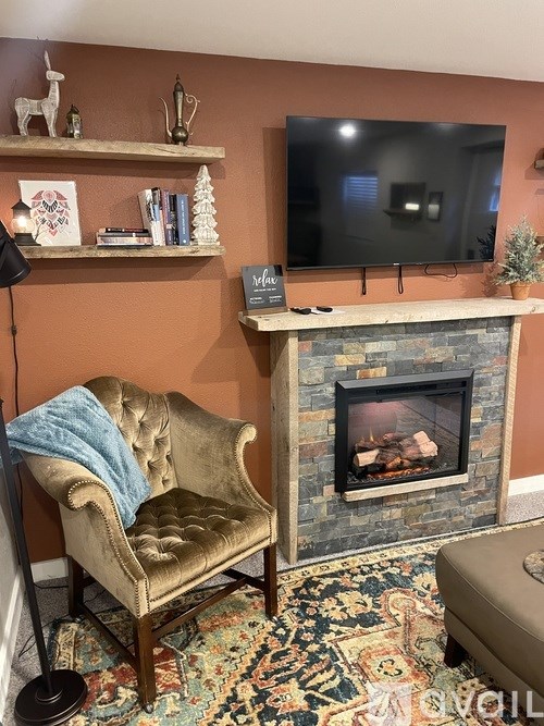 A living room with a fireplace, a chair, and a television.