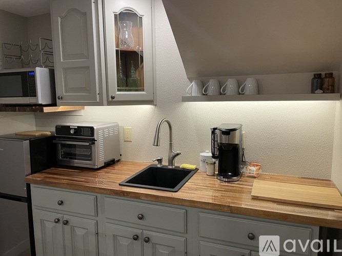 A kitchen with a wooden countertop and a coffee maker on it.