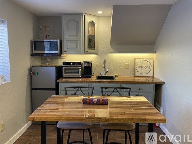 A kitchen with a wooden table and stools.