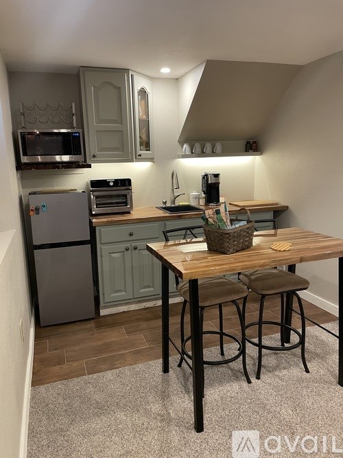 A kitchen with a table and chairs.