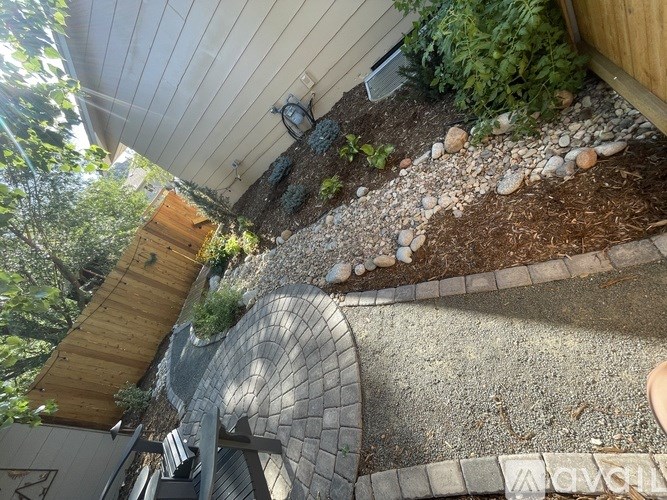 A backyard with a gravel path and a wooden deck.