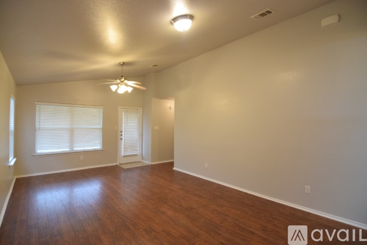 A room with wooden floors and a ceiling fan.