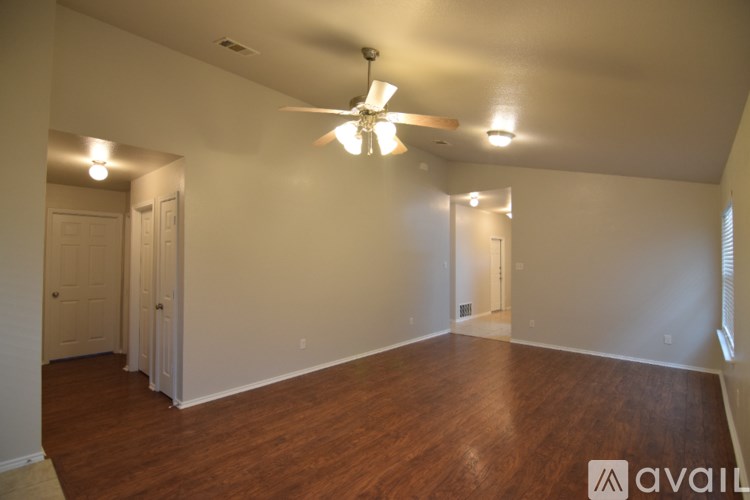 A room with a carpeted floor, a door, and a window with blinds.