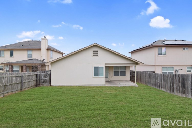 A house with a fence and a yard is available for rent.
