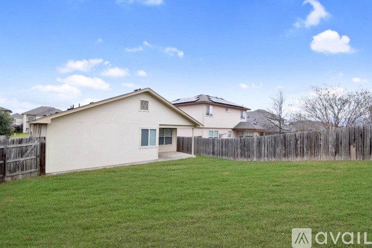 A house with a fence and a tree in the backyard.