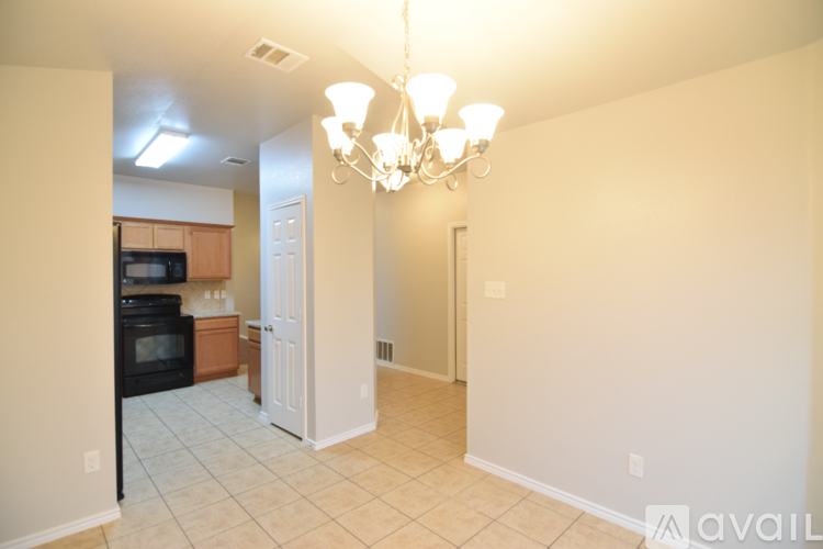 A kitchen with wooden cabinets and a black refrigerator.