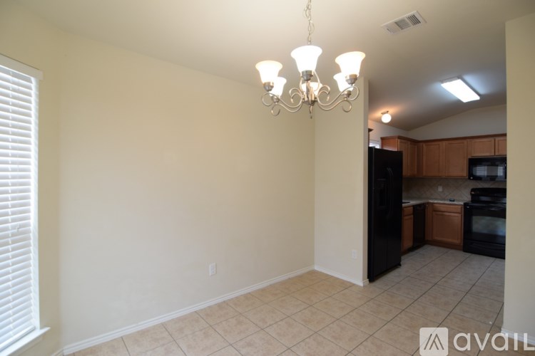 A kitchen with a black refrigerator and wooden cabinets.
